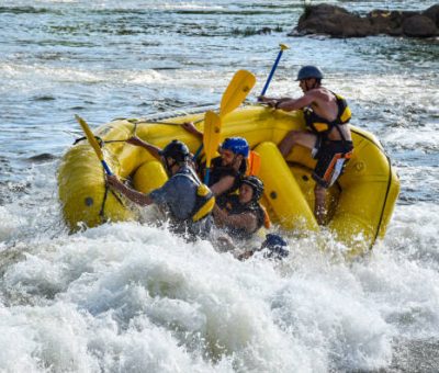 Raft tipping in rapids with occupants struggling for control. Raft tipping in rapids with occupants struggling for control.