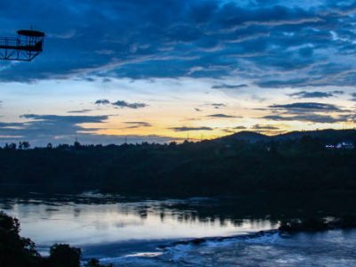 Sunset reflections over the Nile River and bungee jumping tower in Jinja, Uganda Water rafting at the River Nile