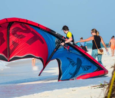 Zanzibar, Tanzania - Tourists enjoy in kiteboarding on the sandy beaches of Zanzibar.