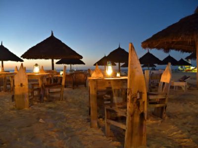 Romantic night on Indian ocean shore. Beach cafe and lighting lanterns, Kendwa beach, Zanzibar, Tanzania, Africa. Selective focus on the lantern